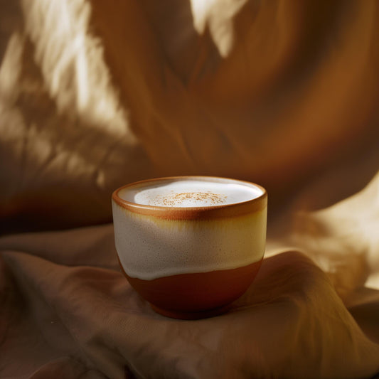 A cup of coffee with milk foam in warm morning light